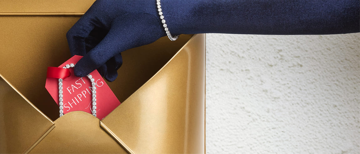 A gloved hand takes a diamond bracelet attached to a red card labeled 'Fast Shipping' from a golden envelope